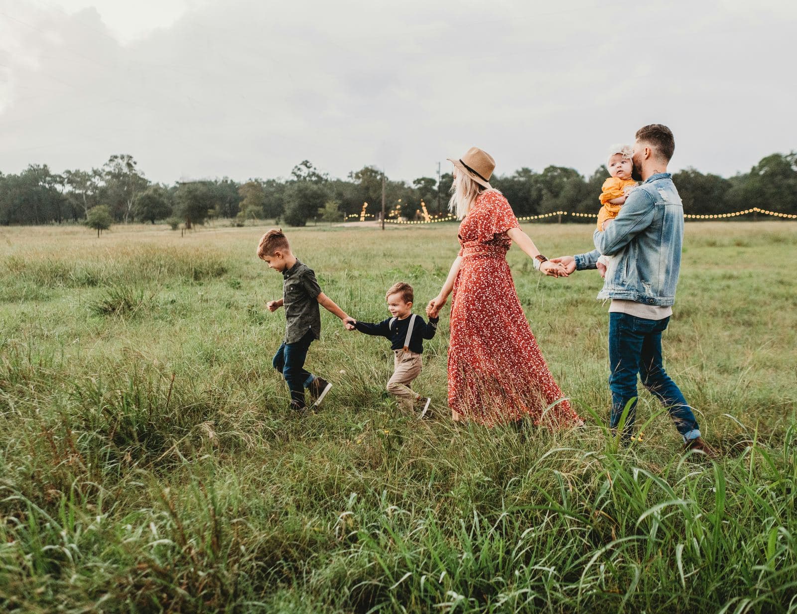 A family walking together through a grassy field at dusk